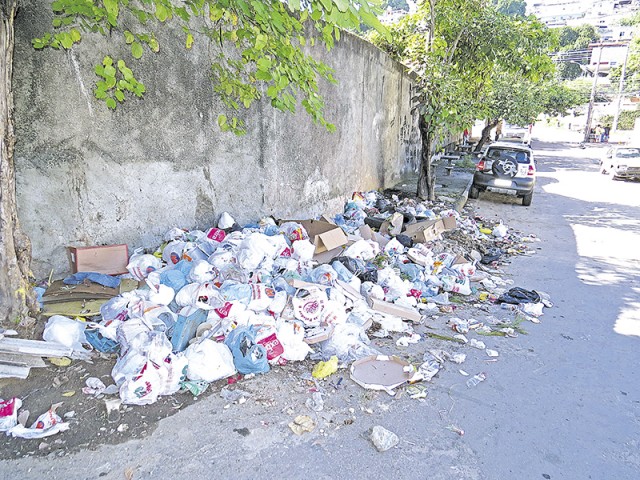Sacos de lixo tomam a calçada da Rua Itacuã